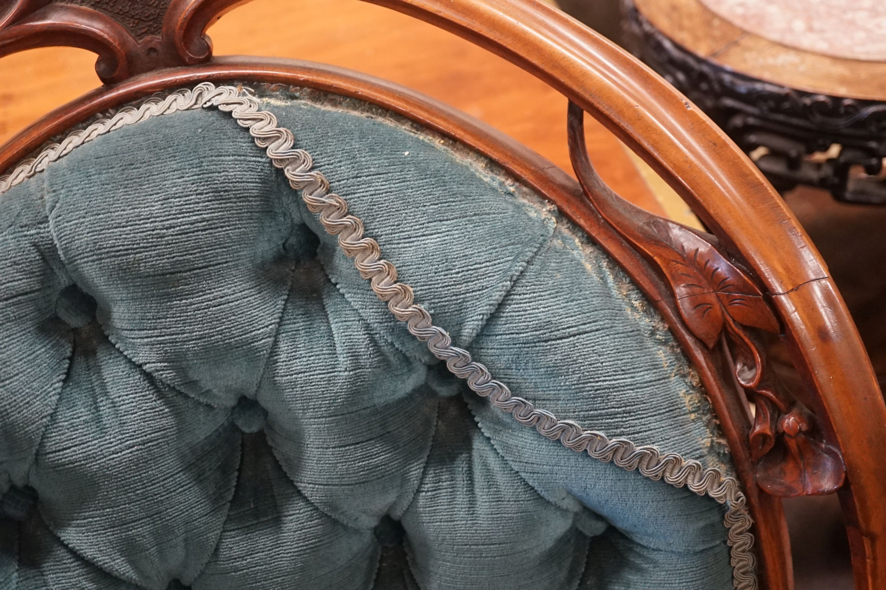 A Victorian carved mahogany spoon back salon chair with buttoned blue upholstery